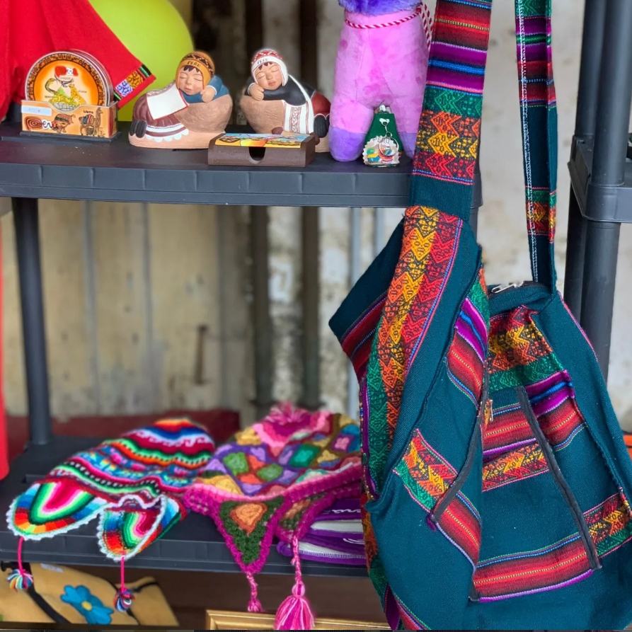 Puesto con artesanías peruanas, tejidos y chullos de lana en la romería
